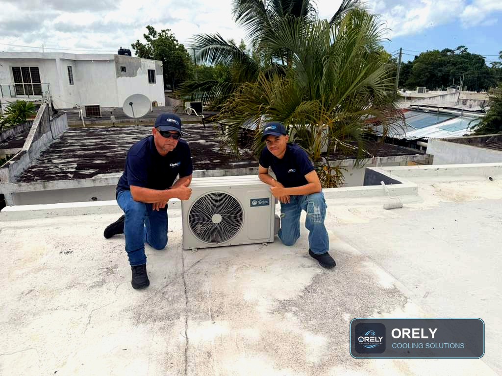 ORELY technicians kneeling beside an outdoor AC unit